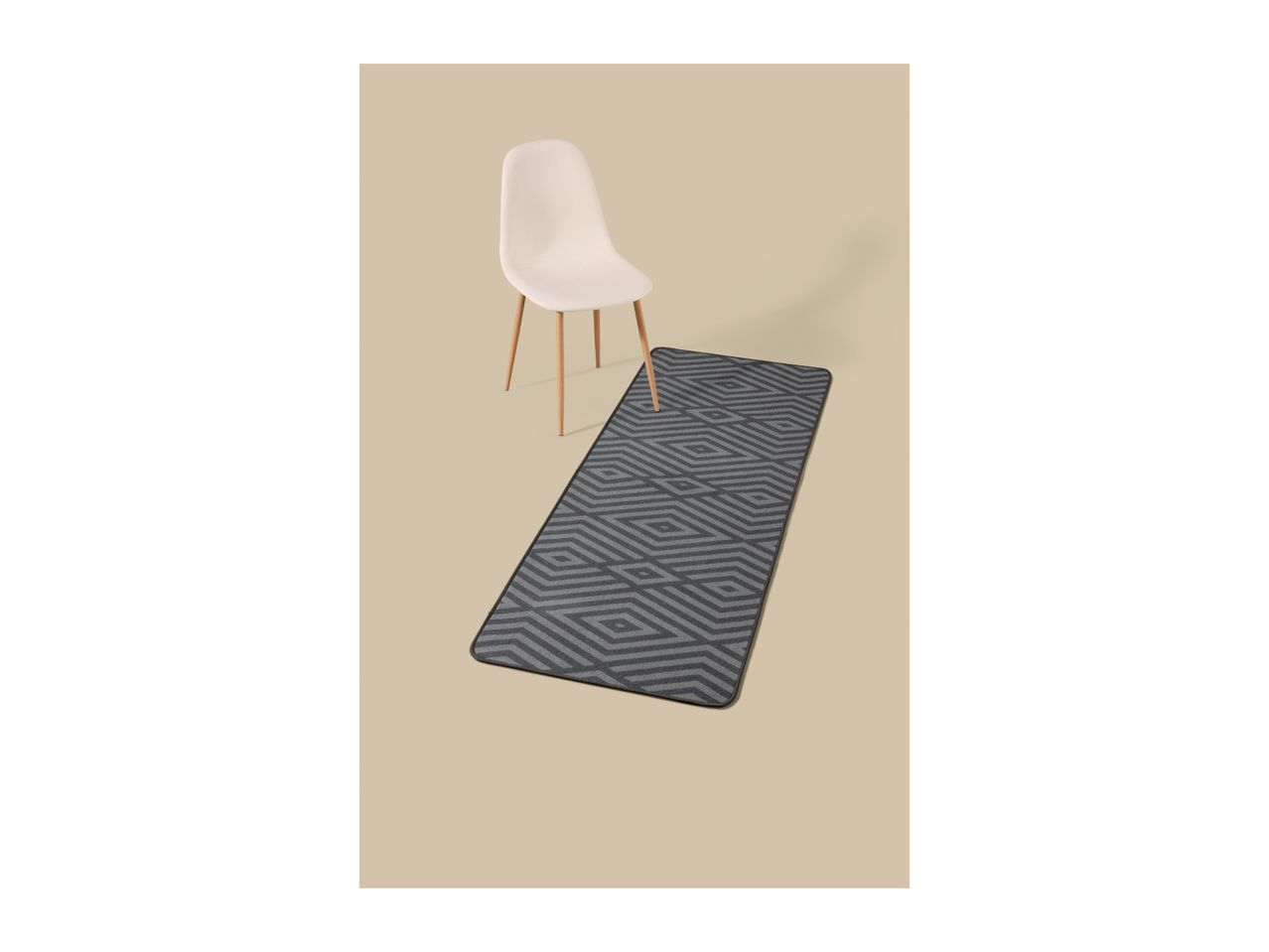 A white chair and a grey geometric patterned runner rug on a beige background.
