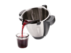 Ein Edelstahl-Küchenhelfer gießt rote Flüssigkeit in ein Glas.