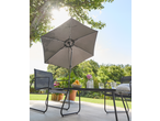 Outdoor patio set with a dark grey umbrella, table, and chairs, featuring oranges and drinks.