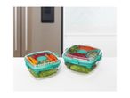 Two clear salad containers with teal lids, filled with fresh vegetables, on a white surface.