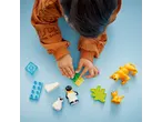 Child playing with building blocks and animal figures on a blue background.