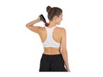 Woman in sports bra using a massage gun on her shoulder and neck.