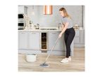 Woman mopping a modern kitchen floor with a mop and bucket.
