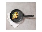 Frying pan with roasted potatoes and vegetables on a white napkin, top view.