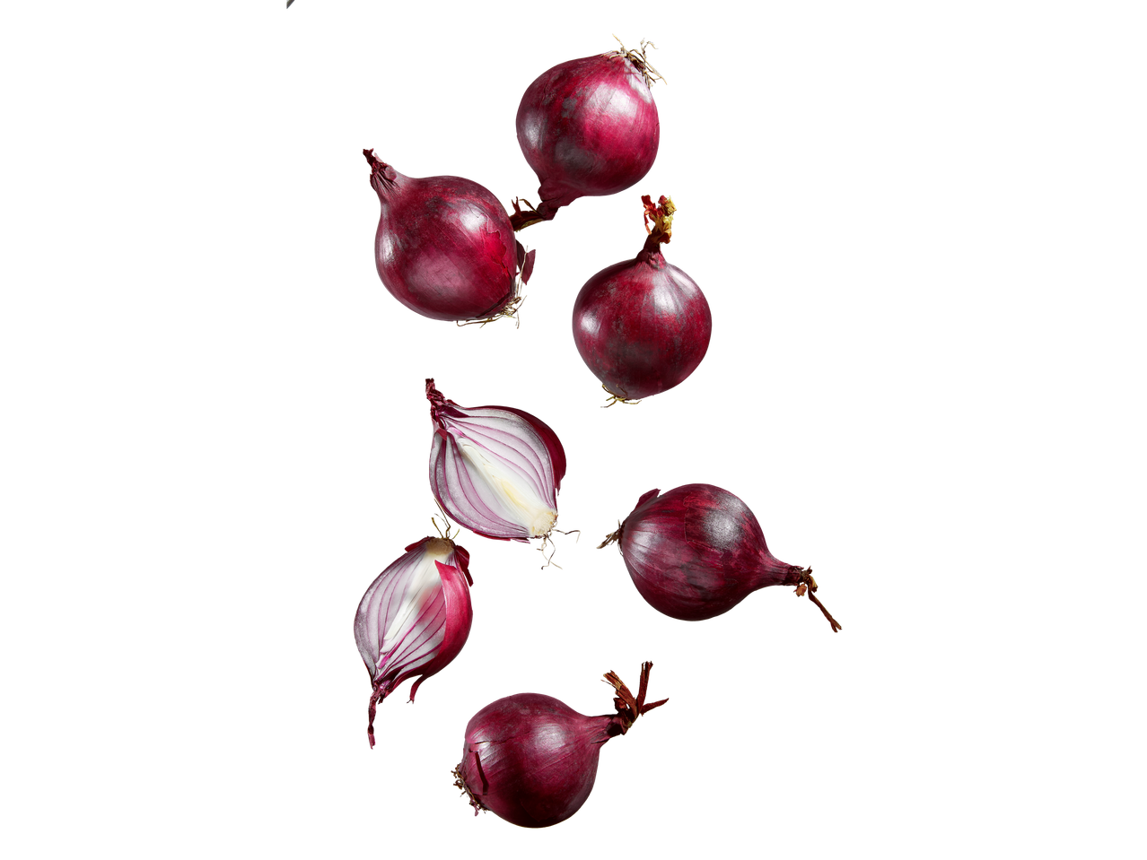 Punased sibulad, mõned pooleks lõigatud, langevad mustal taustal.