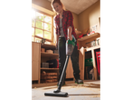 Woman using a PARKSIDE® 20V Cordless Handheld Vacuum Cleaner to clean sawdust.