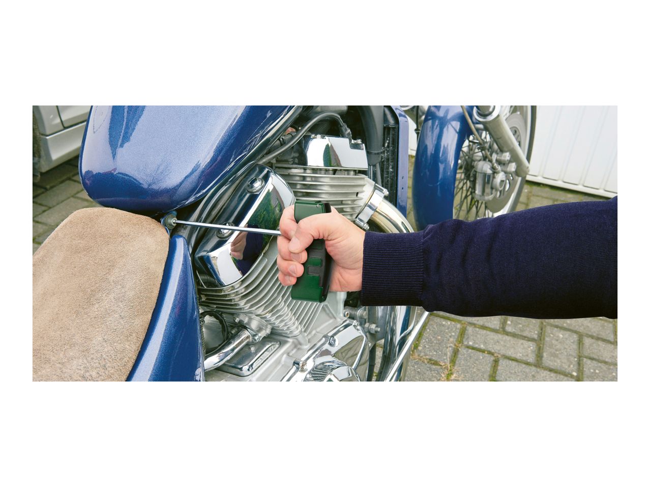 Hand using a torque wrench on a motorcycle engine