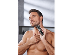 Man shaving his beard with a Braun trimmer.