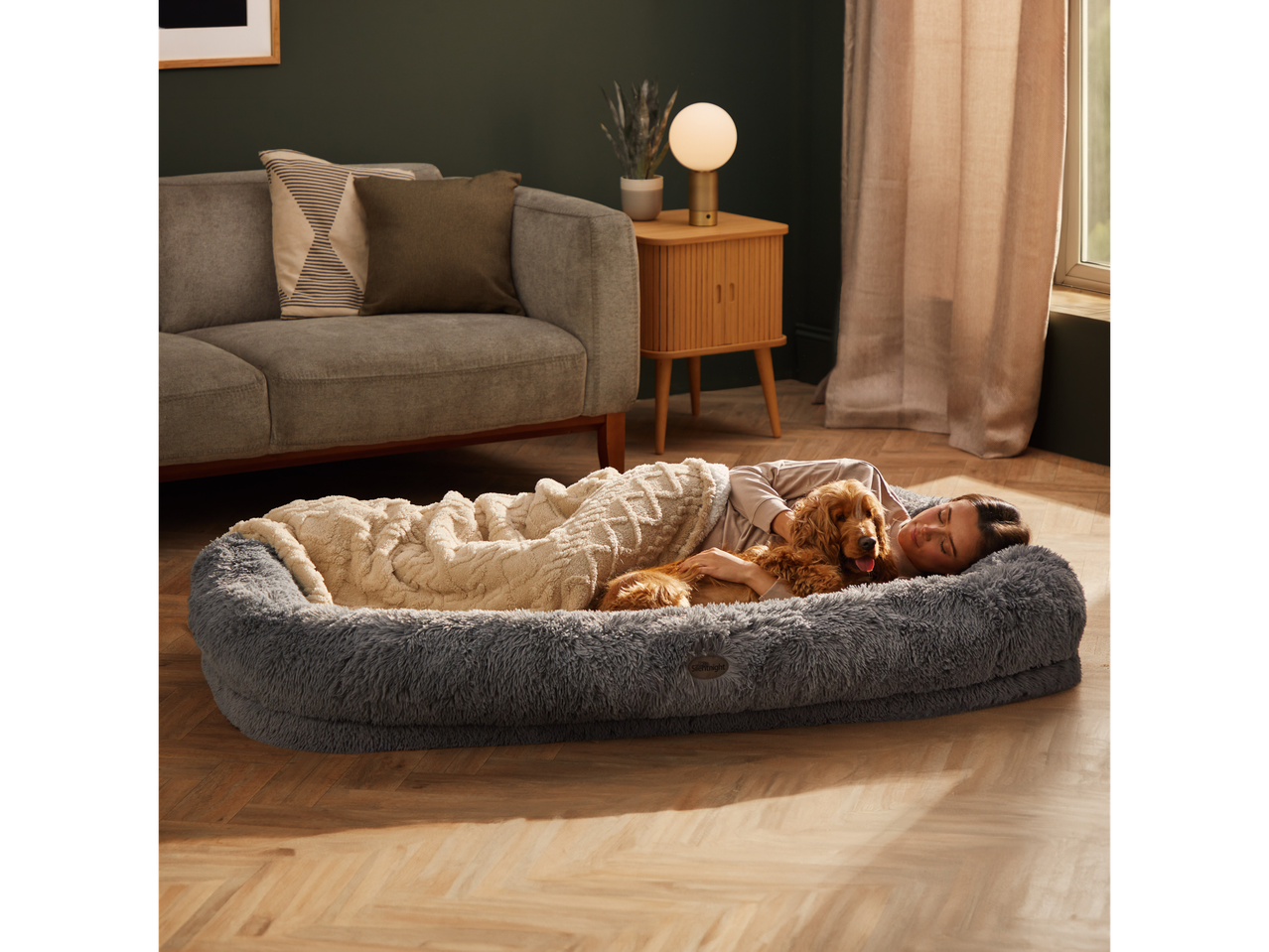 Silentnight Human Pet Bed with a woman and dog relaxing on it in a living room.