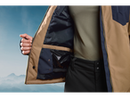 Crivit ski jacket with open interior showing pockets, worn by a person against a mountain backdrop.