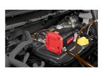 An electric oil pump connected to hoses inside a car engine bay.