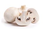 Whole and sliced button mushrooms.