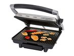 A black and silver contact grill cooking various foods.
