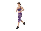 Woman running in a purple sports bra and patterned capri leggings.