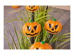 Halloween pumpkin path lights in a garden setting.