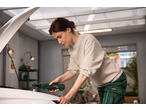 Woman using a PARKSIDE cordless ratchet wrench to repair a car.