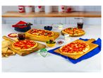 Several small, ready-to-eat pizzas on wooden boards, alongside drinks and toppings.