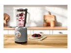 A SilverCrest blender with berries and yogurt on a wooden kitchen counter.
