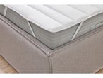 A mattress topper with elastic straps is shown on a bed.