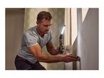 Man using a work light and scraper to prepare a wall for painting.