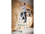 Man on a ladder installing electrical wiring on a wooden wall.