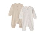 Two baby sleepsuits, one beige and one white with gold stars.