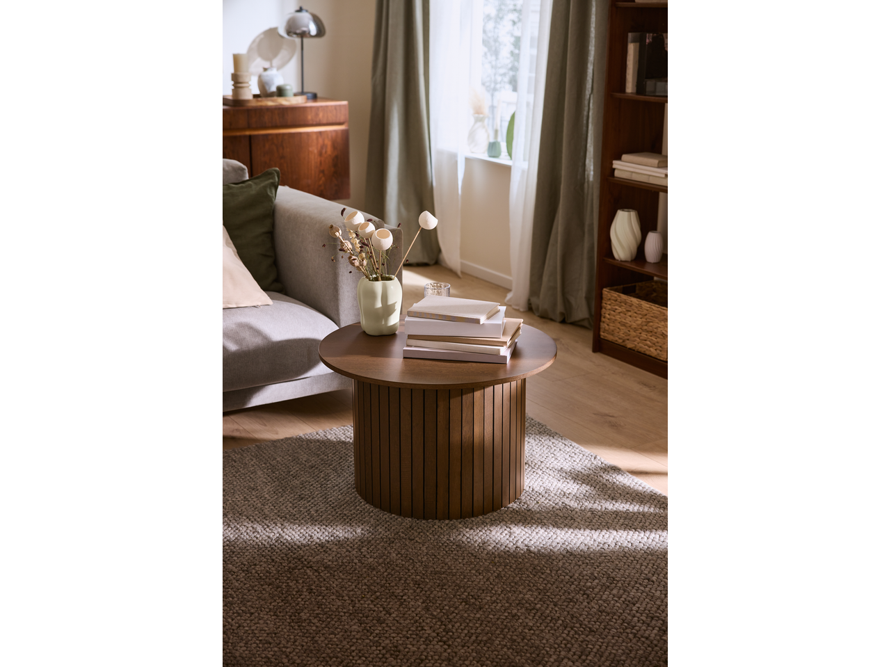 Livarno vase with dried flowers on a round wooden coffee table in a cozy living room.