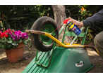 Uma pessoa pulveriza WD-40 na roda de um carrinho de mão verde.