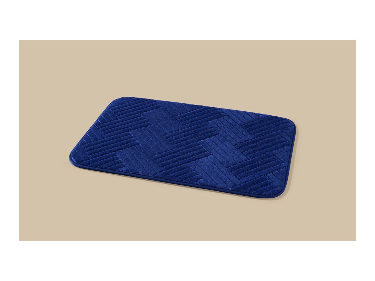 Blue bath mat with a textured herringbone pattern on a beige background.