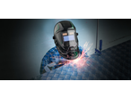 Person wearing a PARKSIDE® Automatic Welding Helmet while welding metal.