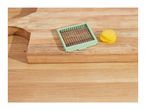 A vegetable slicer and sliced potatoes on a wooden cutting board.