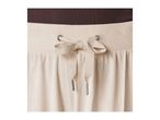 Close-up of beige sweatpants with a brown ribbed waistband and a drawstring tie.