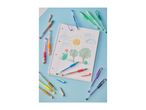 Colorful gel pens scattered around a notebook with a child's drawing of a sunny landscape.