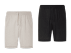 Zwei Paar kurze Jogginghosen, eine beige und eine schwarze.