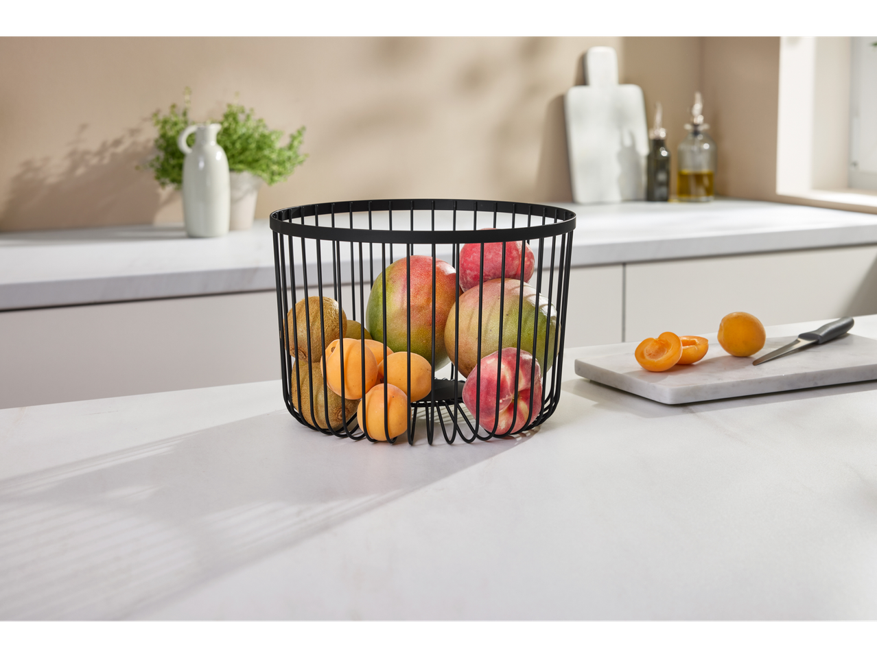 Coș de fructe SILVERCREST® cu fructe asortate pe un blat de bucătărie.