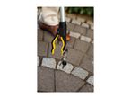 A person using a grabber tool to pick up a set of keys from a paved surface.