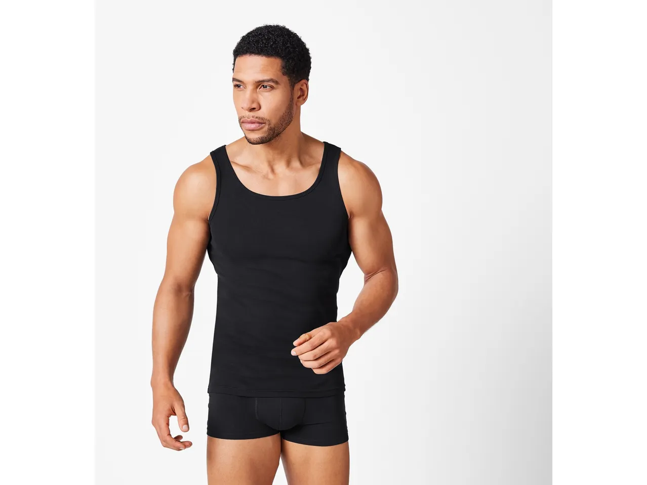 Uomo con canotta nera e boxer neri.