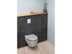 A modern toilet with a gray seat, flush plate, and a wooden shelf with decor.