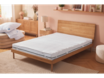Mattress topper and pillows on a wooden bed.