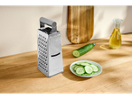 Ralador de cozinha Silvercrest® com pepino e azeite numa tábua de madeira.