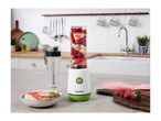 Breville blender with fruit, a smoothie bowl, and a water bottle on a kitchen counter.