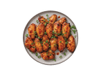 Taldrik teriyaki kastmes kanatiibadega, kaunistatud rohelise sibulaga.