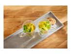 Two glass mugs of lemon and mint tea with cookies on a grey tray.