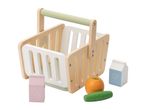 Wooden toy shopping basket with play food items like milk, juice, an orange, and a cucumber.