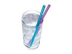 Glass of sparkling water with ice and two colorful straws