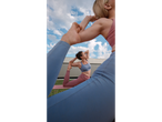Two women in CRIVIT sports leggings and sports bras practicing yoga outdoors.