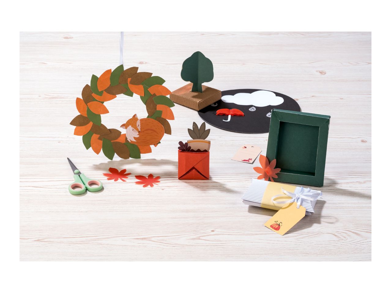 Autumn-themed paper crafts including a wreath, tree, and gift box.