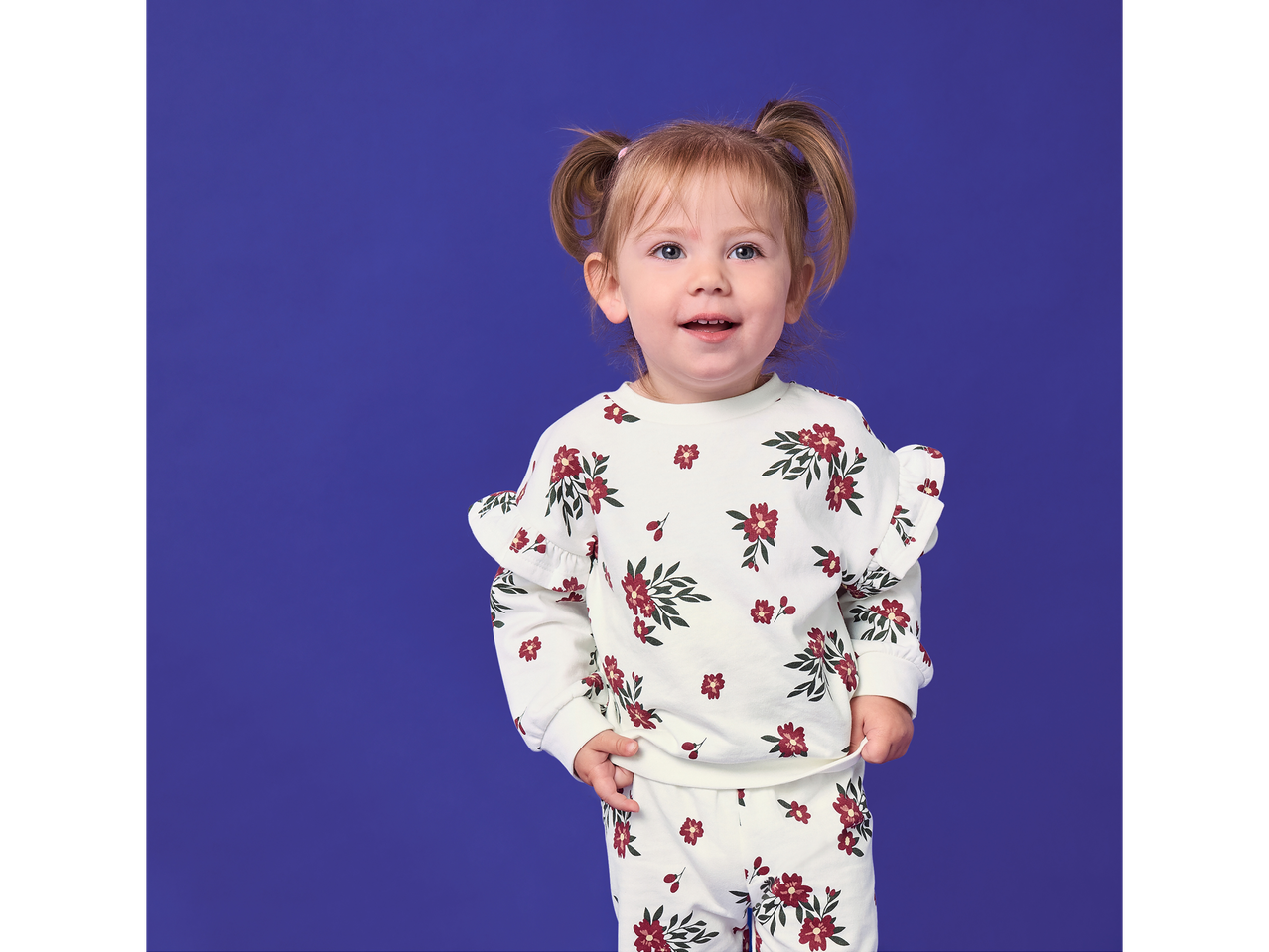 Fetiță în bluză lupilu® cu imprimeu floral.