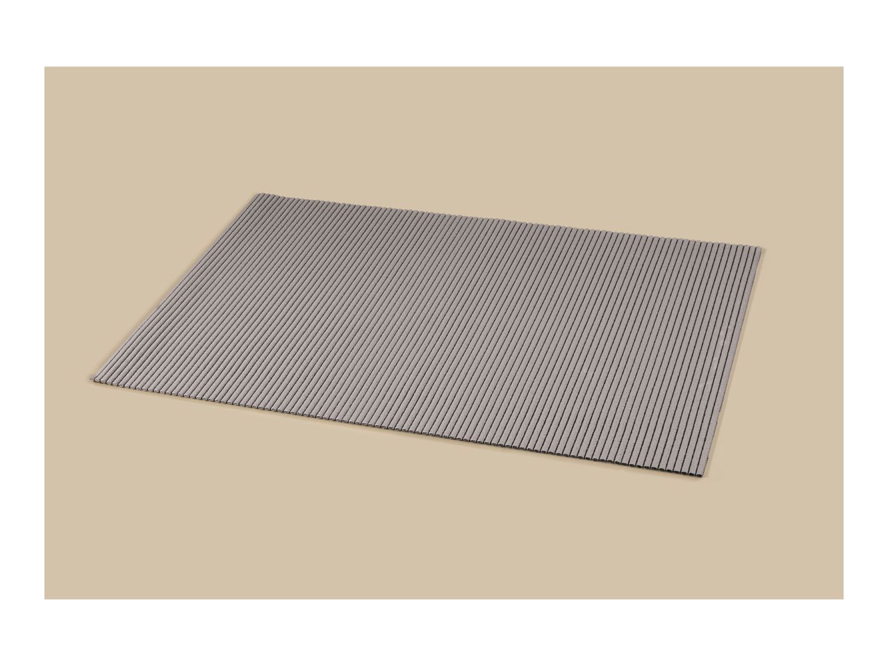 Grey ribbed placemat on a beige background.