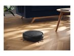 Robotic vacuum cleaner on a wooden floor in a living room
